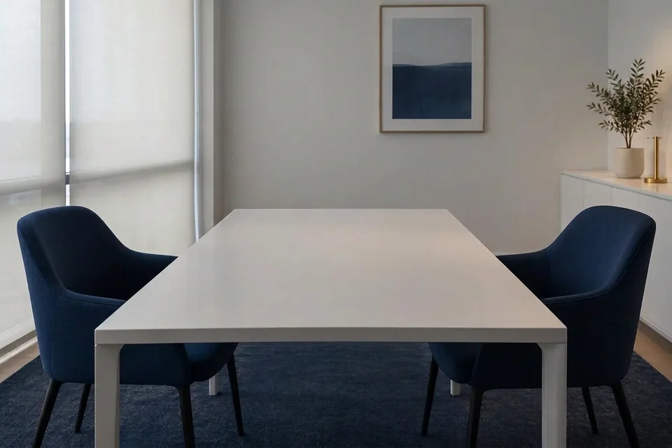 Architectural detail: a quiet meeting room with a white table and two navy chairs